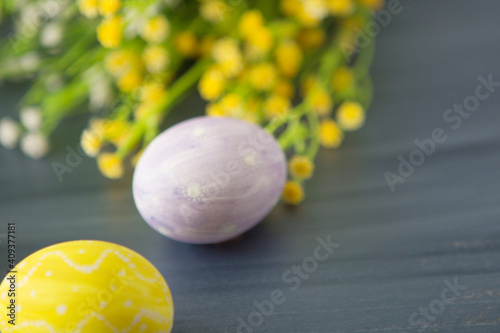 Colorful easter decoration with and flowers on gray wooden table. Top view