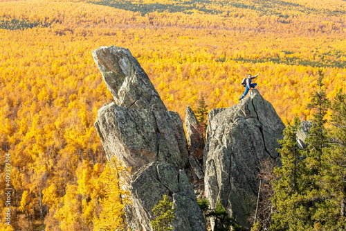 mature tourist posing on the rocks of the mountain round hill on the Alabiya ridge in the Ural mountains on an autumn sunny day. photo