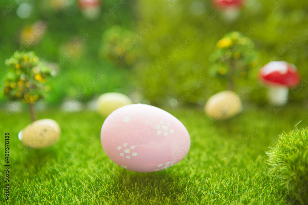 Little Easter bunny toys and Easter eggs on green grass. Fairy tale