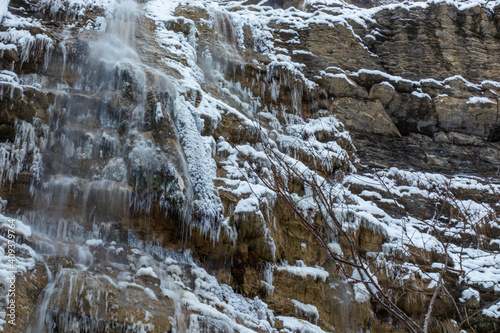 icicle waterfall in the mountains with snow in winter in cold weather
