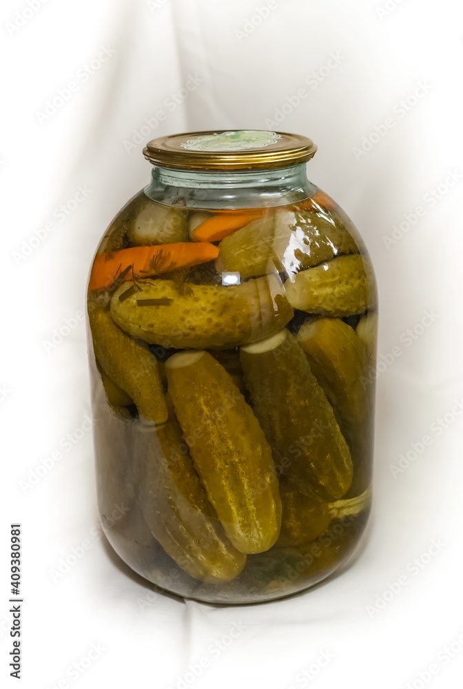 Pickles in a rolled-up metal lid three-liter glass jar on a white background Pickles in a rolled-up metal lid three-liter glass jar on a white background