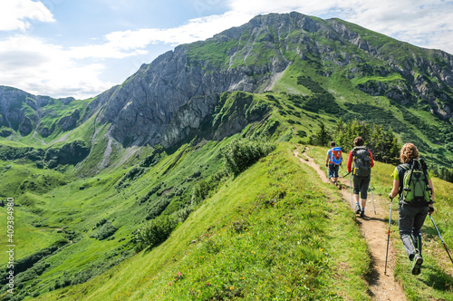 Drei Bergwanderer unterwegs auf einem Pfad nahe der Kanzelwand im Kleinwalsertal photo