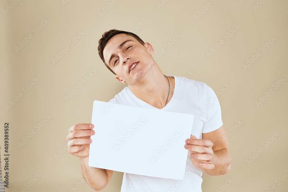 man in white t-shirt sheet of paper in hands Copy Space cropped view beige background man in white t-shirt sheet of paper in hands Copy Space cropped view beige background