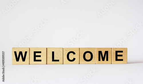 Text Welcome on wooden cubes that lie on a white background