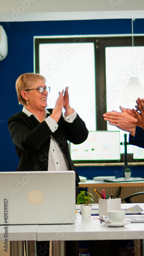 Motivated happy diverse business team people clapping celebrating success at corporate meeting. Multiethnical designers giving high five during corporate brainstorm receving good news enjoying victory photo