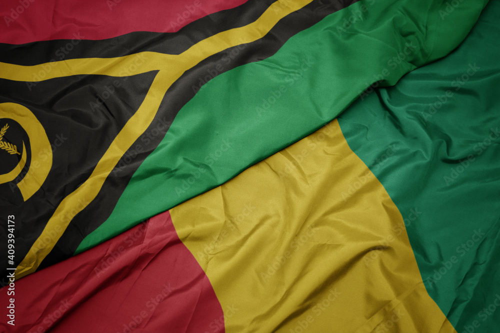 waving colorful flag of guinea and national flag of Vanuatu .