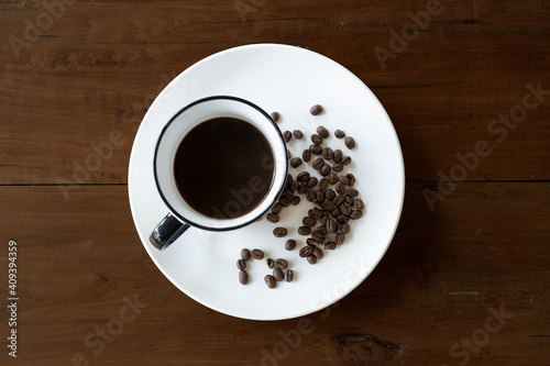 Coffee Cup On Roasted Coffee Beans wood table