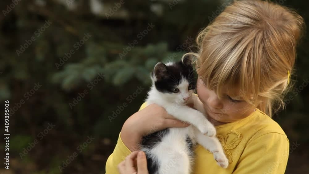 LIttle girl playing with kitten in the garden LIttle girl playing with kitten in the garden
