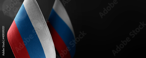 Obraz na plátne Small national flags of the Russia on a dark background