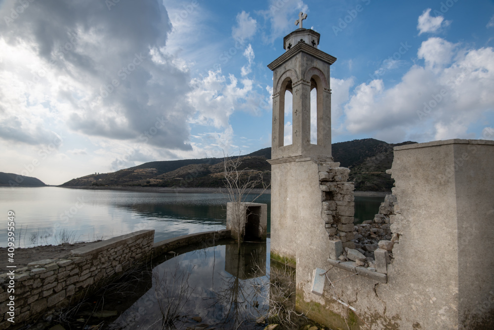 Ruins of an abandoned and deserted church in the water of a dam.