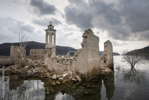 Ruins of an abandoned and deserted church in the water of a dam. photo