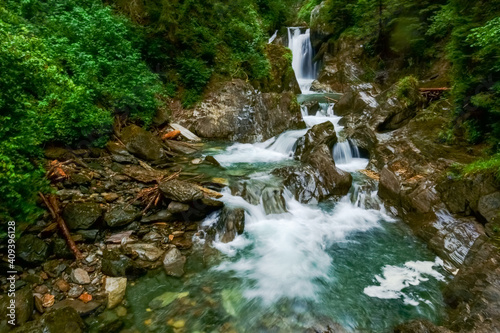 green clear water in a mountain brook with waterfalls