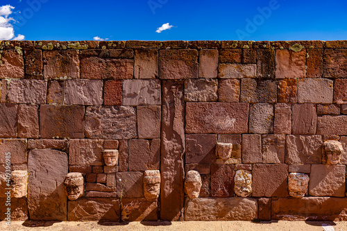 Bolivia. Tiwanaku (or Tiahuanaco) - Pre-Columbian ancient site on a list of the UNESCO World Heritage Site. Part of wall of Semi-Subterranean Temple covered with tenon heads of many different styles photo