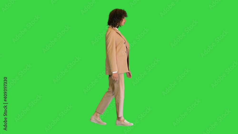 Young African American businesswoman walking on a Green Screen, Chroma Key. Young African American businesswoman walking on a Green Screen, Chroma Key.