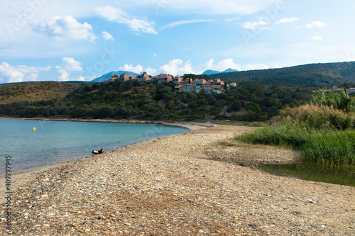 Beautiful natural beach called Plage D'Orzo with a holiday resort in the background, near St. Florent. Corsica, France. Tourism and vacations concept.