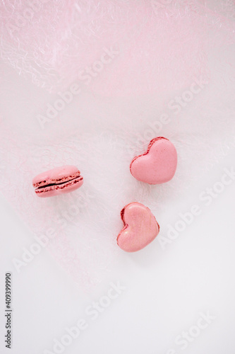 Heart-shaped macaroonson a pink background.