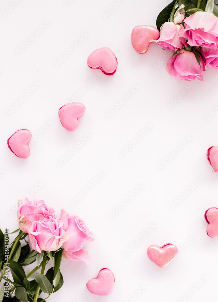 Pink macaroons on a white background with pink roses