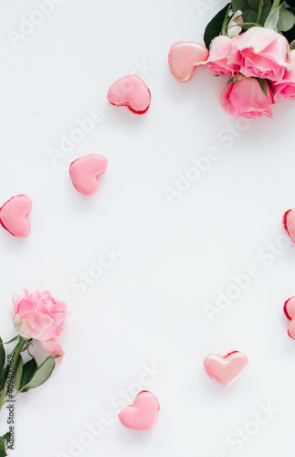 Pink macaroons on a white background with pink roses bakcground