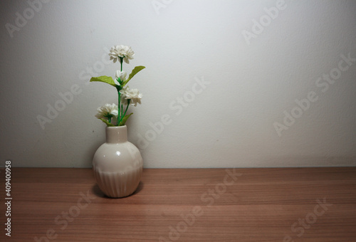 White flowers in vintage vase on wooden table, floor, gray cement wall Stylish stock image format for banner templates, text artwork, quotes, fonts, festivals