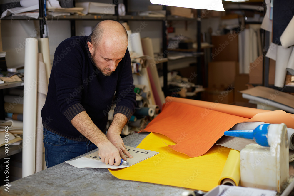 craftsman cutting leather with cutter in workshop craftsman cutting leather with cutter in workshop