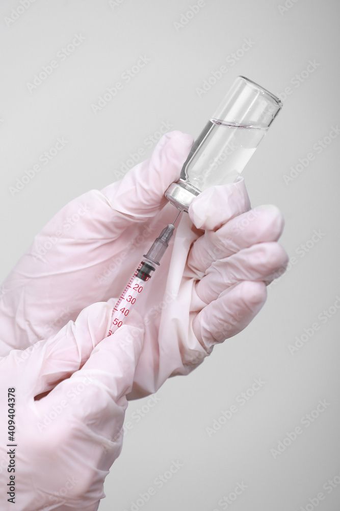 Doctor, nurse or scientist hand in white medical gloves holding flu, measles, coronavirus vaccine shot for diseases outbreak vaccination, medicine and drug concept Doctor, nurse or scientist hand in white medical gloves holding flu, measles, coronavirus vaccine shot for diseases outbreak vaccination, medicine and drug concept