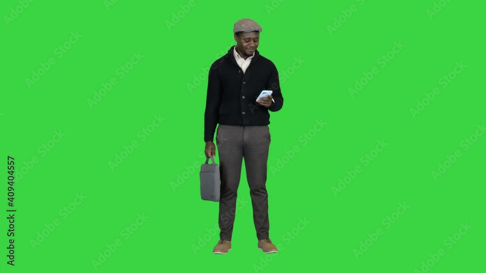Handsome black man in a hat texting on a Green Screen, Chroma Key. Handsome black man in a hat texting on a Green Screen, Chroma Key.
