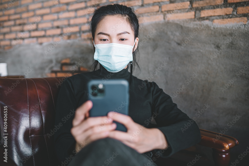 Asian women wearing medical masks with using a mobile phone. 