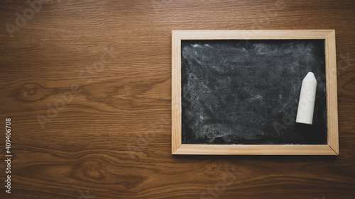 Black Dirty and Dusty Chalkboard on wooden background with copy space. photo