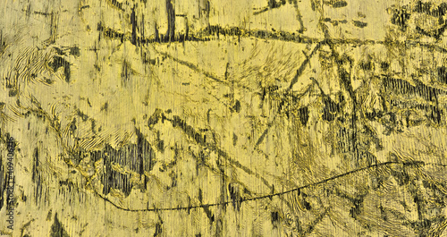 Grungy uneven yellow painted wooden surface deep scratches wall texture background