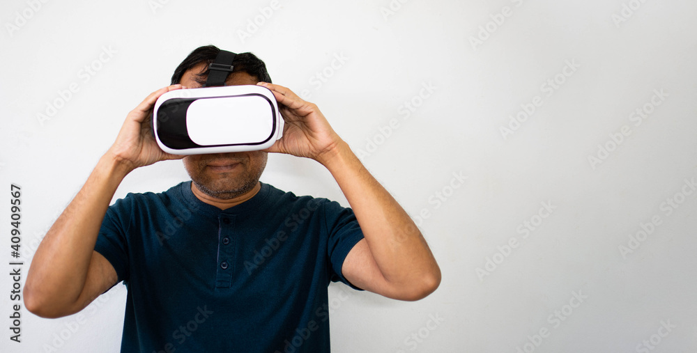A man smiling and with both hands holding Virtual reality (VR) white and black. The young man was happy while watching a tutorial on how to exercise with an RV. Virtual reality wearing a male head.