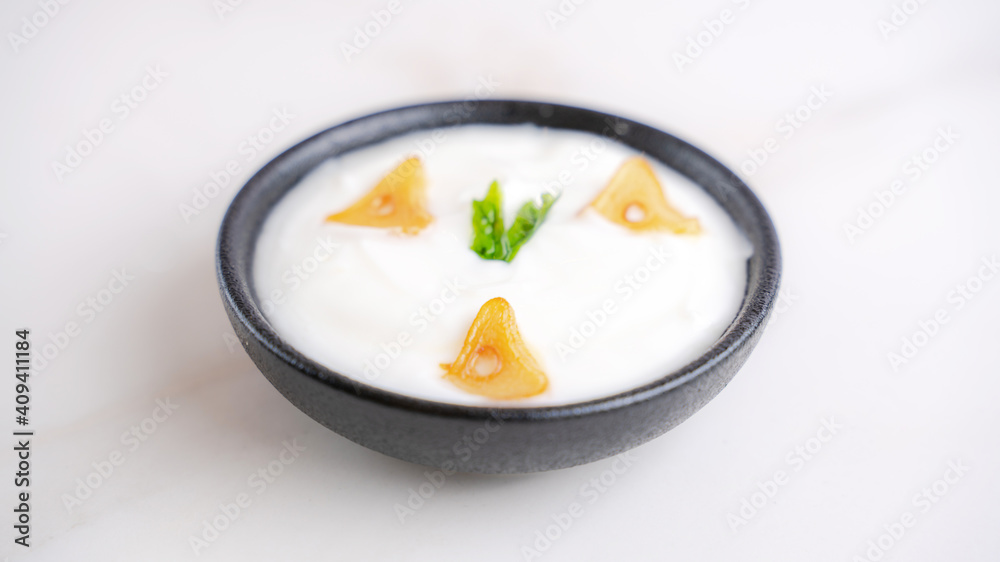 Garlic sauce in a bowl with few pieces of garlic topping. Garlic sauce in a bowl with few pieces of garlic topping.