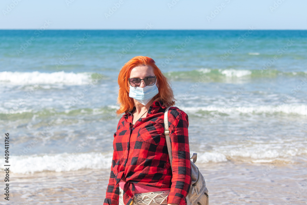 Beautiful girl with red hair on the seashore