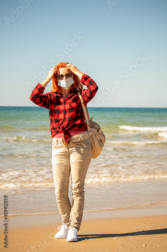 Beautiful girl with red hair on the seashore