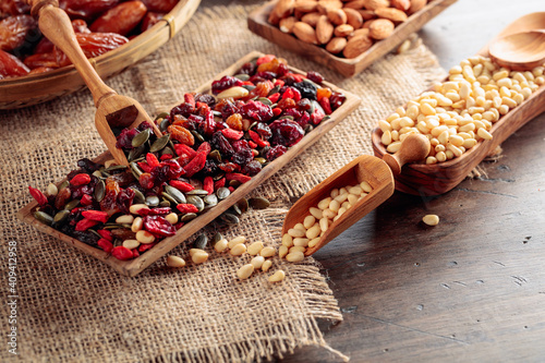 Dried fruits, various nuts, berries, and seeds on a wooden table.
