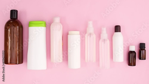 Bottles with cosmetics products move on pink theme. Stop motion 