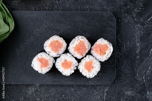 Sushi rolls with salmon on a black background