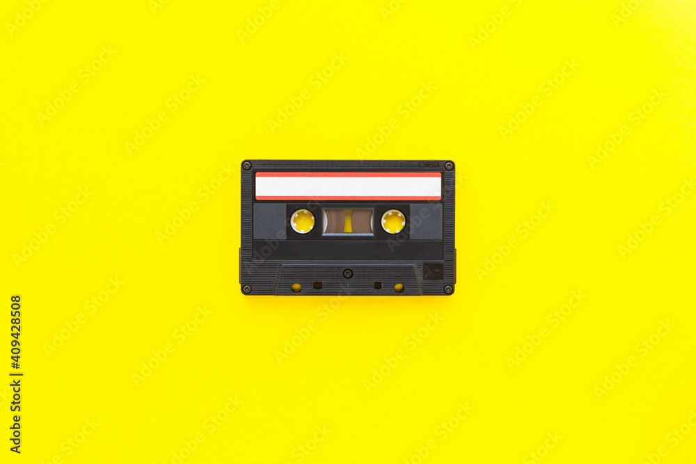Retro audio tape cassette from 80s and 90s isolated on yellow background. Old technology concept. Flat lay, top view with copy space.