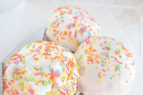  A set of Easter cakes in multi-colored sprinkles. Easter cakes on a festive table with Christian Easter bread