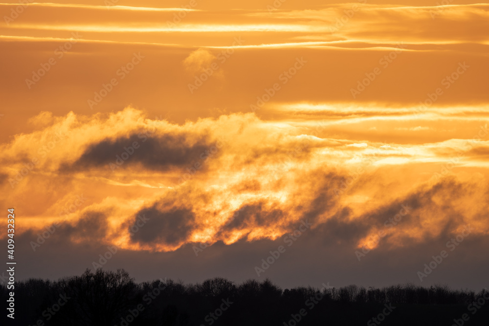 Winter sky at sunset with golden light and dramatic clouds