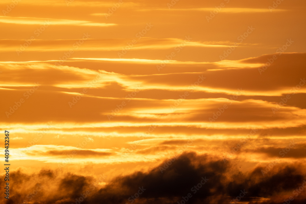 Winter sky at sunset with golden light and dramatic clouds