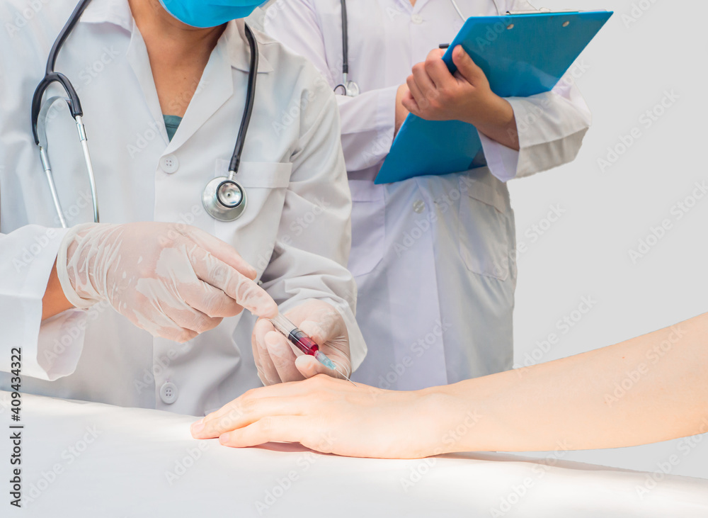 closeup hands of doctor use syringe on patient’s hands do blood test with trainee standing beside and taking note. white copy-space, healthcare medical care concept closeup hands of doctor use syringe on patient’s hands do blood test with trainee standing beside and taking note. white copy-space, healthcare medical care concept