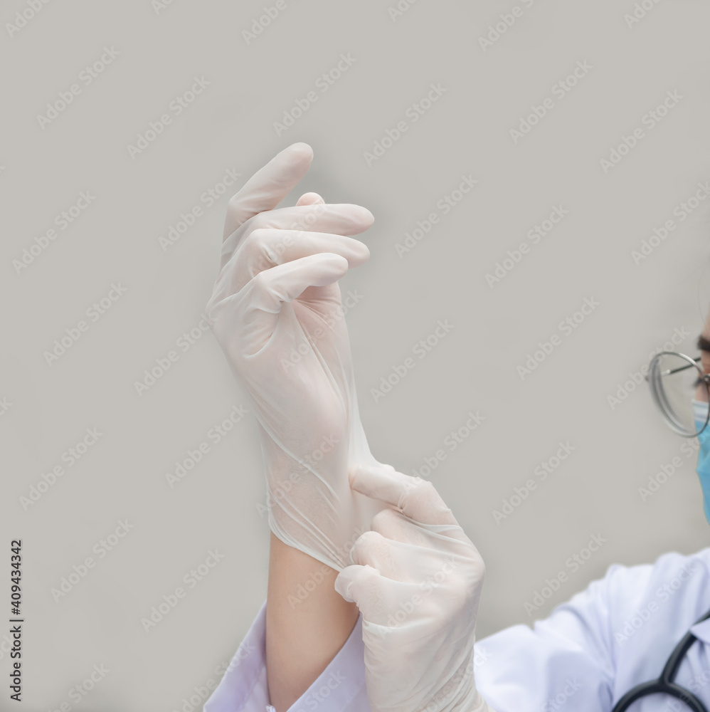 Female doctor preparing for the work, she is wearing gloves and looking at hand, healthcare and preparation concept Female doctor preparing for the work, she is wearing gloves and looking at hand, healthcare and preparation concept