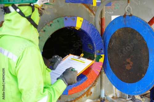(Focus on Main hole) Construction supervisor use checking to inspect and gas including oxygen record before entering work in confined spaces high risk work construction site.