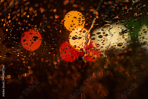 View of the night city through the wet car window with drops
