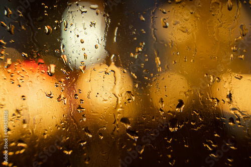 View of the night city through the wet car window with drops