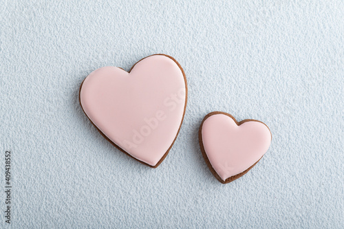 Large and small heart-shaped cookies with icing sugar, white background. Mothers day. Womans day. Valentines day