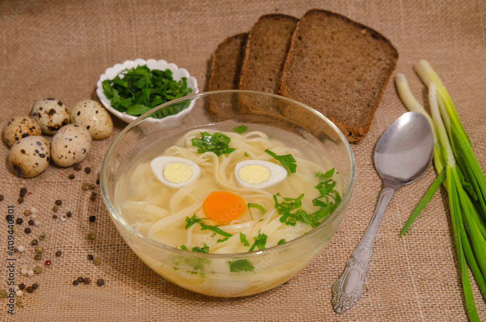 Broth with noodles eggs and herbs on burlap Broth with noodles eggs and herbs on burlap