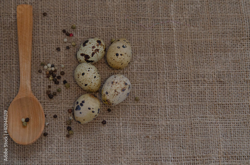 Fresh quail eggs with spices on burlap. Space for text