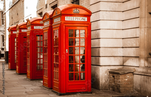 Five traditional old style red phone boxes in London, UK. Sepia vintage photo.