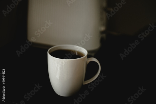 kawa, herbata w białym kubku, filiżance, czarny blat, poranek 